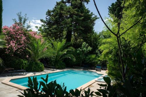 une piscine dans un jardin avec des arbres et des buissons dans l'établissement Le Manoir d'Amiel a secret 16 bedroom garden oasis for groups up to 30, à Villegailhenc