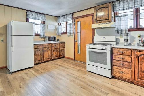 a kitchen with white appliances and wooden cabinets at Hilltop Home with Grill, In Wayne Natl Forest in Logan