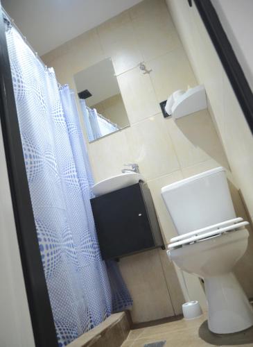 a bathroom with a toilet and a sink and a mirror at SmartBox Campana in Campana