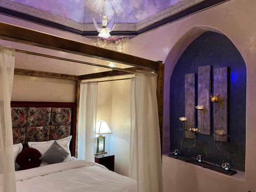 een slaapkamer met een hemelbed en een paars plafond bij Riad Al Ibtikar in Marrakesh