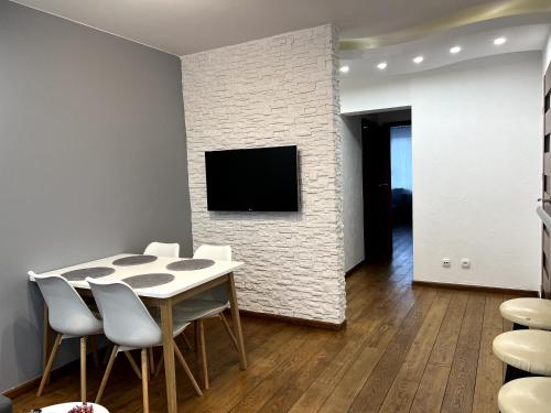a dining room with a table and chairs and a tv at Apartament Tuwima 6 in Ełk