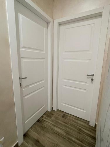an empty room with two doors and a wooden floor at A boné Guest house in Catania