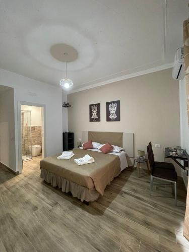 a bedroom with a bed and a table and a desk at A boné Guest house in Catania