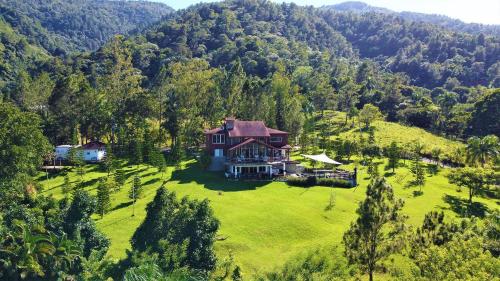 an aerial view of a house on a green field at Villa Bartolo By Hospedify - Lujo y mejor vista de Jarabacoa Piscina Billar Rio in Jarabacoa