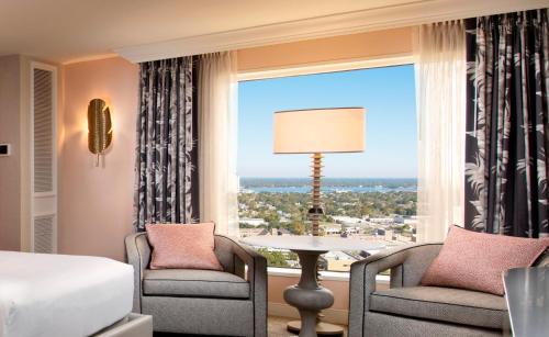 um quarto de hotel com uma cama e duas cadeiras e uma janela em Beau Rivage Resort & Casino em Biloxi