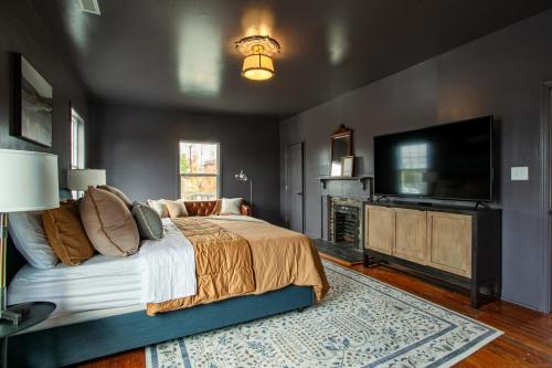 a bedroom with a bed and a flat screen tv at Pruett Place Downtown Home in Knoxville