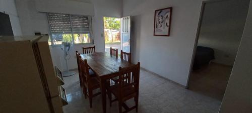 uma sala de jantar com uma mesa de madeira e cadeiras em Alojamientos Litoral - Casa del Sol em Gualeguaychú