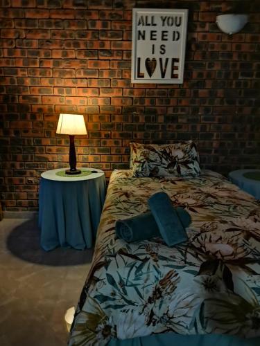 a bedroom with a bed and a table with a lamp at Dreamers nest in Richards Bay