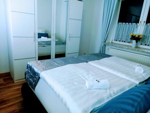 a bedroom with a large white bed with a window at Pine Crest Ferienwohnung in Harzgerode