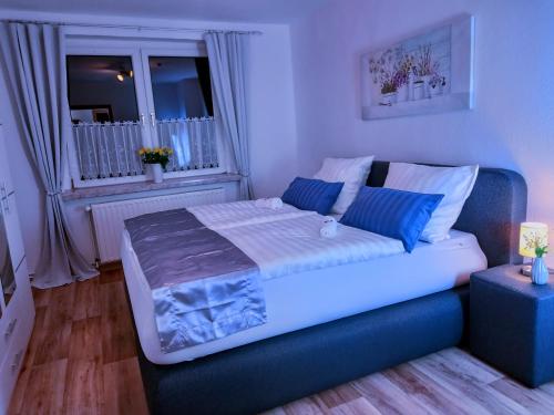 a bedroom with a large bed with blue pillows at Pine Crest Ferienwohnung in Harzgerode