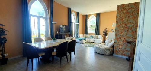 une salle à manger avec une table et des chaises et un salon dans l'établissement Best seaview Penthouse+77m2 privat roof terrace near beach and Cannes, à Vallauris