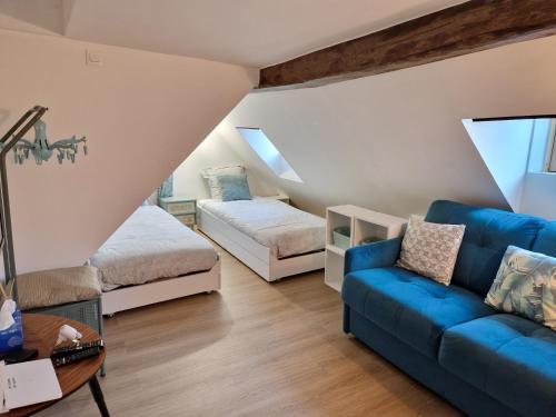 un salon avec un canapé et un lit dans l'établissement New Inn Paris, à Paris