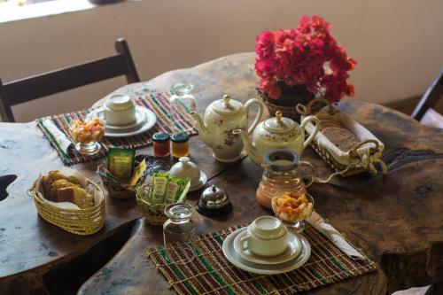 uma mesa com um conjunto de chá sobre ele com um vaso de flores em Ciamat Camp em Santo Amaro