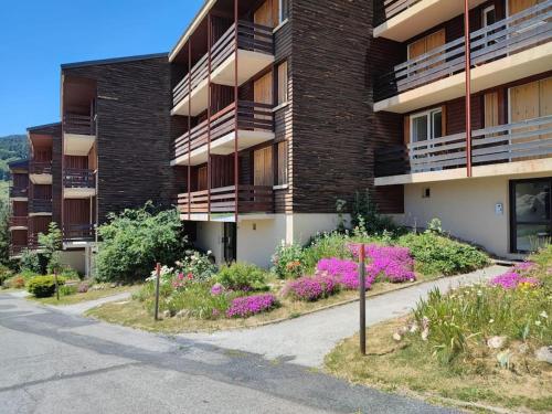 un edificio de apartamentos con flores delante en Le balcon cerdan, en Font-Romeu-Odeillo-Via