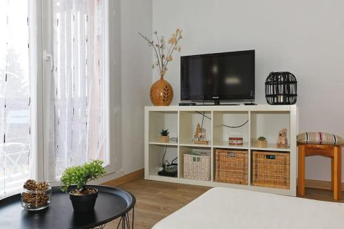 una sala de estar con TV en un armario blanco en Le balcon cerdan, en Font-Romeu-Odeillo-Via