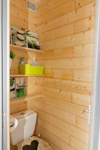 La salle de bains est pourvue de toilettes et d'un mur en bois. dans l'établissement Le balcon cerdan, à Font-Romeu-Odeillo-Via