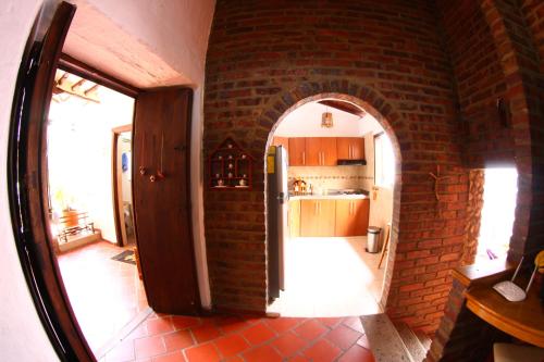 une cuisine avec un mur en briques et une porte ouverte dans l'établissement Real Dream Hostel, à San Gil