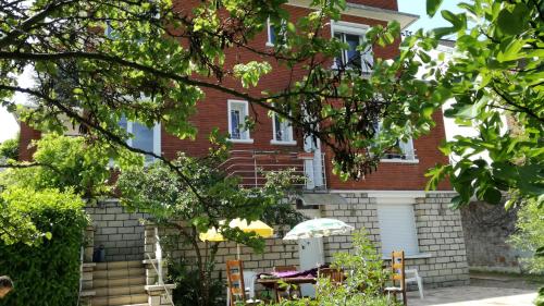 ein Haus mit einem Tisch und einem Sonnenschirm davor in der Unterkunft 3 private rooms shared flat in a villa at Sceaux 600m RER B direct to Notre-Dame in Sceaux
