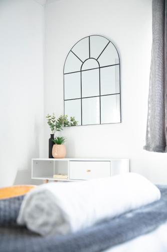 a bedroom with a bed with a dresser and a window at NEC/Airport/HS2/Resorts World in Marston Green