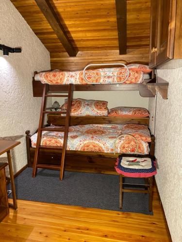 a room with two bunk beds and a table at CASA FOLGARIDA 2 BOX AUTO PRIVATI davanti CABINOVIA BELVEDERE in Folgarida
