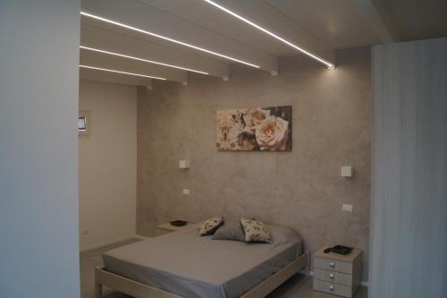 een slaapkamer met een bed en een schilderij aan de muur bij Il Parco Casa Vacanze in Lecce