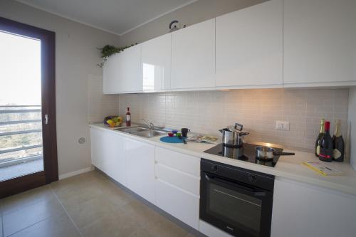 a kitchen with white cabinets and a sink at Residence Milano Bicocca in Milan