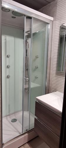 a glass shower in a bathroom with a sink at House Orlando in Sferracavallo