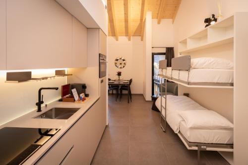 Zimmer mit Etagenbetten, einem Waschbecken und einer Küche in der Unterkunft Residenza 3544 in Lumino