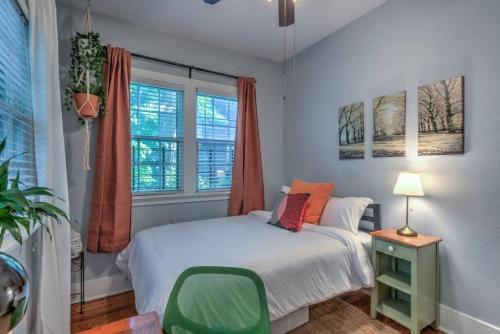 a bedroom with a bed and a green chair at Urban Zen Great Location in Memphis