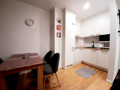 ヤホリナにあるApartman Winter magic Snježna dolinaのテーブルと椅子のあるキッチンとダイニングルーム