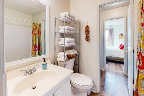 a bathroom with a sink and a toilet and a mirror at Villas on the Gulf H10 in Pensacola Beach