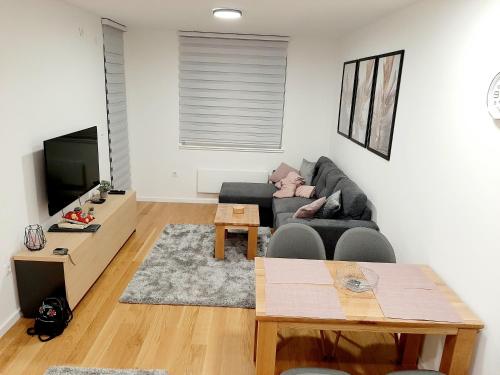 ein Wohnzimmer mit einem Sofa und einem Tisch in der Unterkunft Apartman Winter magic Snježna dolina in Jahorina