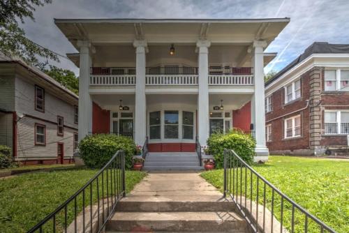 a large brick house with a porch and a gate at Miraculously Modern in a Vintage Shell Midtown in Memphis