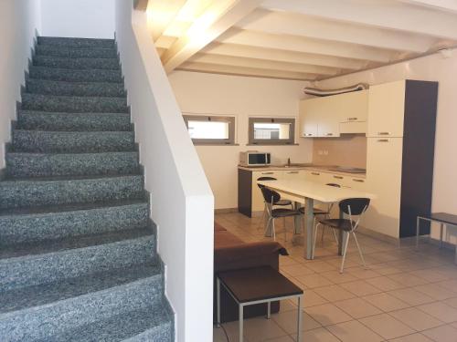 a staircase leading up to a kitchen with a table at Appartamenti tra Lago e Montagna CASA IDEALE LECCO in Lecco
