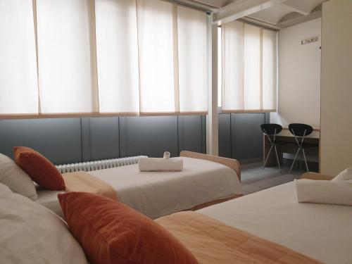 una camera con due letti e due finestre di Apparthotel CASA IDEALE LECCO a Lecco