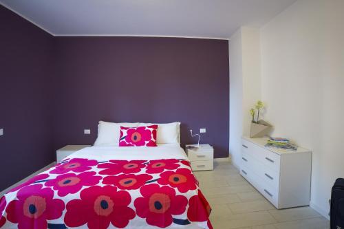 a bedroom with a pink and white bed and a white dresser at Residence Milano Bicocca in Milan