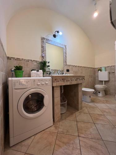 a bathroom with a washing machine and a sink at Saint Michel Apartment in Dolceacqua