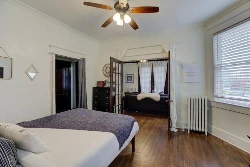 a bedroom with a bed and a ceiling fan at 1900's Historic Getaway - Prime Midtown Location! in Memphis
