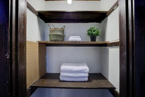 a bathroom with towels on a wooden shelf at 1900's Historic Getaway - Prime Midtown Location! in Memphis