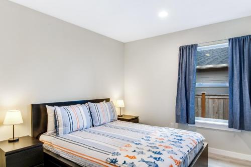 a bedroom with a bed with blue curtains and a window at Salt, Sand, Surf, Repeat in Westport