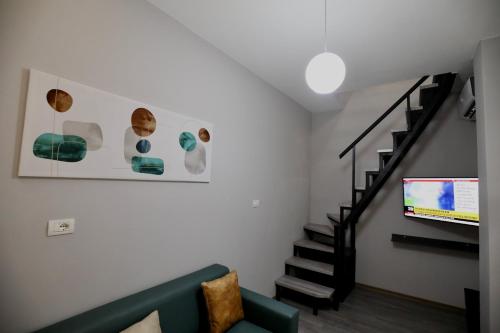 ein Wohnzimmer mit einer Couch und einer Treppe in der Unterkunft Old Town Inn in Pogradec