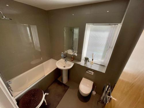 a bathroom with a sink and a toilet and a tub at 2 Bed 2 Bathroom Gated Apartment 1 Inc free Parking in Bromley
