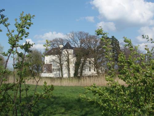an old house in the middle of a field at Burg Boetzelaer in Kalkar