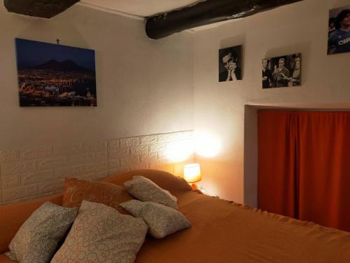 ナポリにあるCasa vacanze Totò & Peppinoのベッドルーム1室(枕、壁に絵画付)