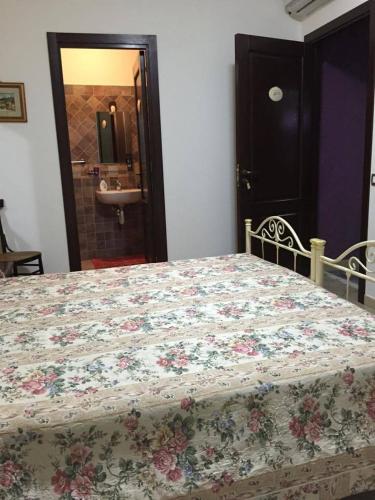 a bedroom with a bed with a floral quilt on it at B&B Ciritorno in Vittoria
