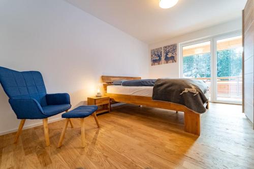 um quarto com uma cama e uma cadeira azul em Ferienwohnung Feldberg Schwarzwald em Feldberg