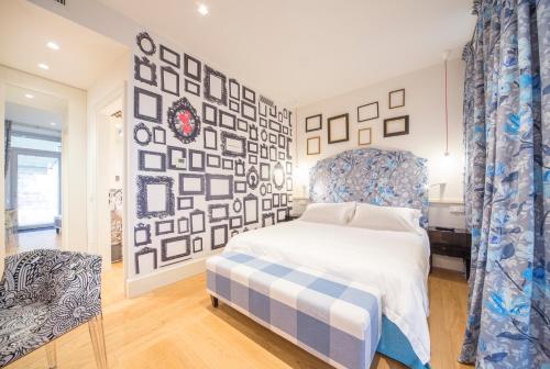 a bedroom with a bed and a wall of pictures at Cinque Rooms in Verona