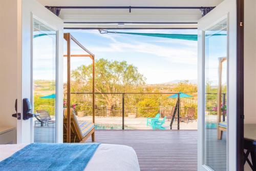 Schlafzimmer mit einem Bett und Blick auf eine Terrasse in der Unterkunft Villa Inn- Adults Only- Temecula Wine Country in Temecula