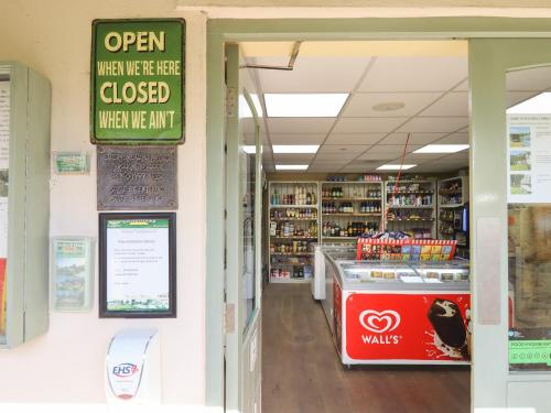 a store aisle with a sign that reads open when were here closed when we at Oak Apple in Newton Abbot