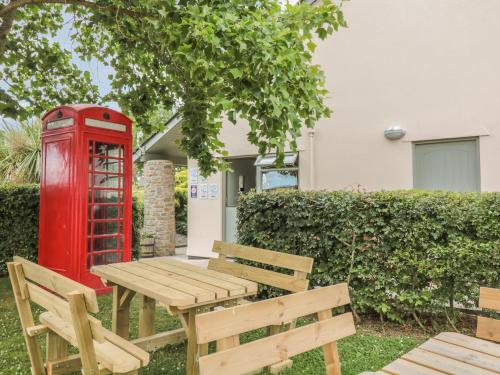 a red phone booth and a wooden table and benches at Oak Apple in Newton Abbot